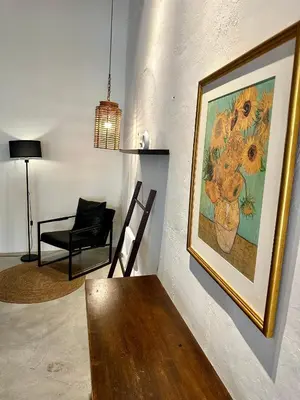 a living room with a painting of flowers on the wall at Melayu Villa by Aayu - 8 mins walk to Armenian St in George Town