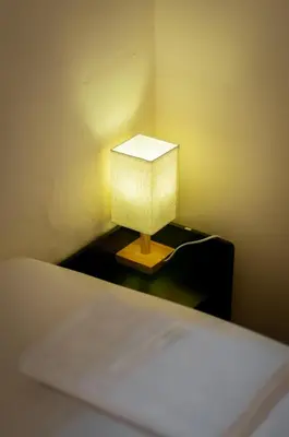 a lamp on a night stand next to a bed at Melayu Villa by Aayu - 8 mins walk to Armenian St in George Town
