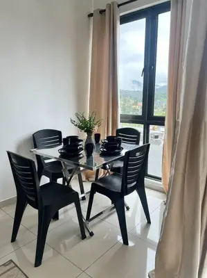 a dining room with a table and chairs and a window at Lily Cameron-Tanah Rata in Tanah Rata