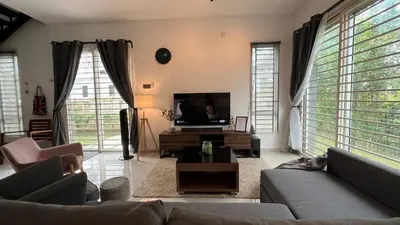 a living room with a couch and a flat screen tv at GardenView Home in Sungai Petani in Sungai Petani