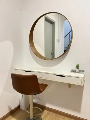 a mirror on a white wall with a chair at GardenView Home in Sungai Petani in Sungai Petani