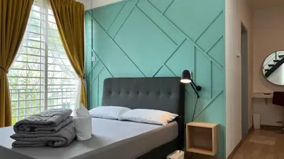 a bedroom with a bed with a blue wall at GardenView Home in Sungai Petani in Sungai Petani