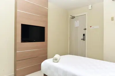 a bedroom with a bed and a tv on a wall at Hotel Mornington Bukit Permata Lumut in Lumut