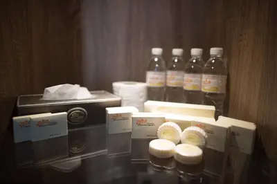 a glass table with bottles of water and paper towels at Hotel Mornington Bukit Permata Lumut in Lumut