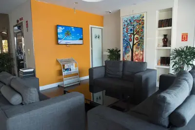 a living room with two couches and a tv at Hotel Mornington Bukit Permata Lumut in Lumut