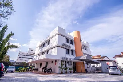 a white building with cars parked in a parking lot at Bahagia Stay Georgetown in George Town