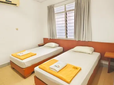 two beds in a room with a window at Bahagia Stay Georgetown in George Town