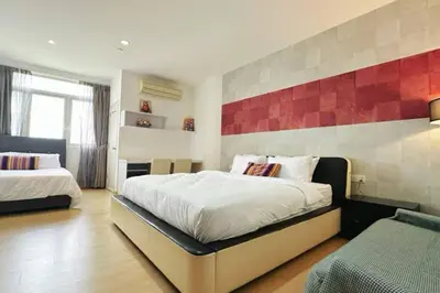 a bedroom with two beds and a red wall at 118 Island Plaza ComFy Seaview Suite in Tanjong Tokong