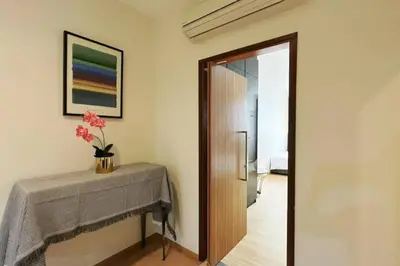 a room with a table and a vase of flowers on the wall at 118 Island Plaza ComFy Seaview Suite in Tanjong Tokong