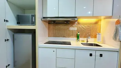 a small kitchen with white cabinets and a sink at 118 Island Plaza ComFy Seaview Suite in Tanjong Tokong