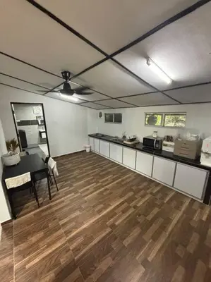 a large room with a kitchen and a table in it at Bagan Serai Simpang Empat Parit Buntar Perak by 3SIBS in Bagan Serai