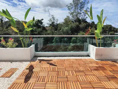 a balcony with a wooden floor and two plants at #MyLuxeGetaway,Quintet Cameron Highlands in Cameron Highlands