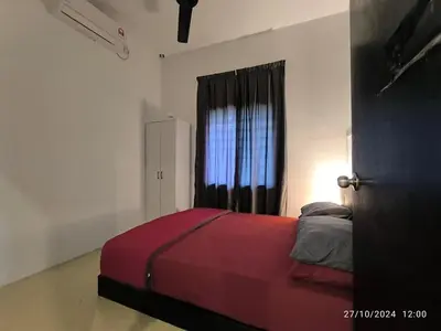 a bedroom with a red bed with a window at a&h homestay in Teluk Intan