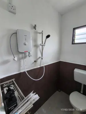 a bathroom with a shower and a toilet in a room at a&h homestay in Teluk Intan