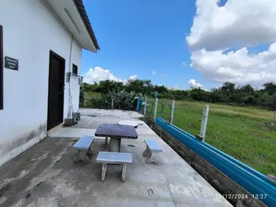 a picnic table and benches outside of a building at a&h homestay in Teluk Intan