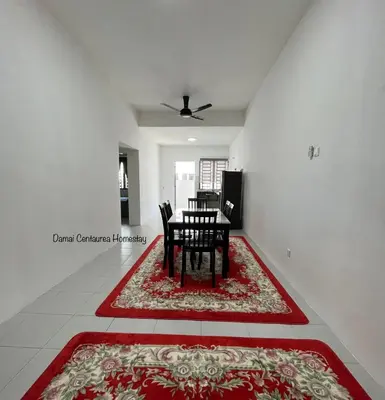 a dining room with a table and chairs on a rug at Damai Centaurea Homestay Utp Uitm Seri Iskandar Perak in Seri Iskandar