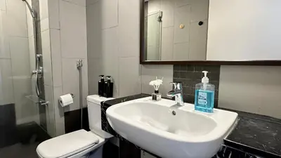 a bathroom with a sink and a toilet at LM HomeyC 3BR Family Suite for 4-14 Pax with Nexflix & Coway Water Purifier in Tanjong Tokong