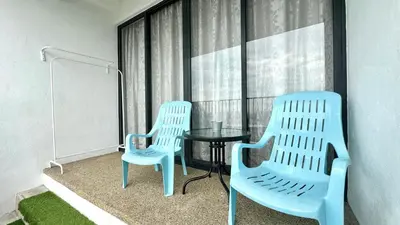two chairs and a table in a room with a window at LM HomeyC 3BR Family Suite for 4-14 Pax with Nexflix & Coway Water Purifier in Tanjong Tokong