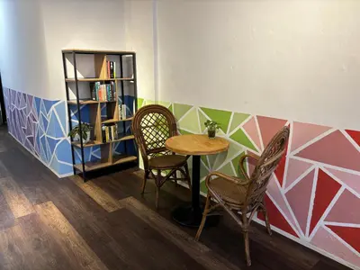 a table and two chairs and a book shelf at Victoria Pods in George Town