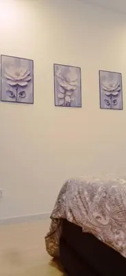 a room with four pictures on a wall with a bed at Crystal Heights Cozy House in Tupai
