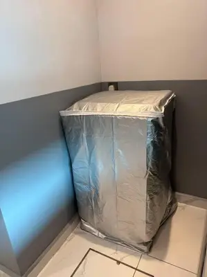 a container wrapped in plastic in a corner of a room at Live Like Your Home, Alma Bukit Mertajam in Bukit Mertajam