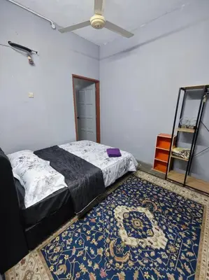 a bedroom with a bed and a rug on the floor at IlhamD' Homestay Kulim 5 Bedroom with 3 Toilet in Lunas