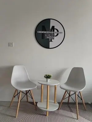 two chairs and a table and a clock on the wall at MyPutra Homestay Parit Buntar in Parit Buntar