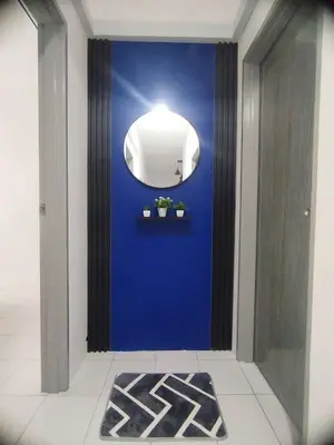 a hallway with a blue wall and a mirror at MyPutra Homestay Parit Buntar in Parit Buntar
