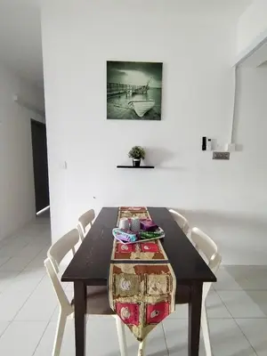 a dining room table with chairs and a picture on the wall at MyPutra Homestay Parit Buntar in Parit Buntar