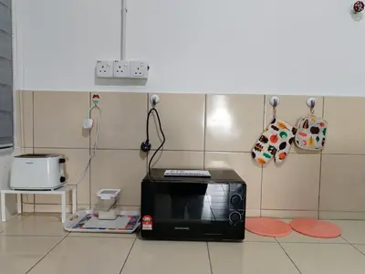a microwave sitting on the floor in a kitchen at MyPutra Homestay Parit Buntar in Parit Buntar