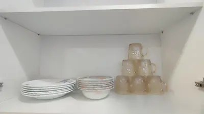 a shelf with plates and bowls and vases at Sweet Home Ipoh in Ipoh