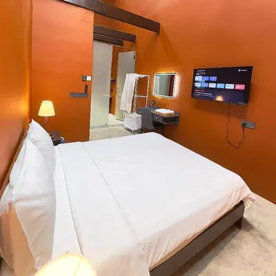 a bedroom with a large bed and a tv on the wall at Hotel Ban Sheng Teik in Ipoh