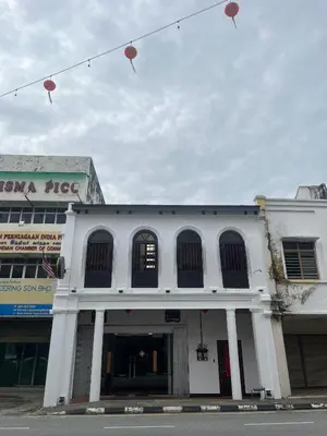 a white building with red lanterns hanging above it at Hotel Ban Sheng Teik in Ipoh