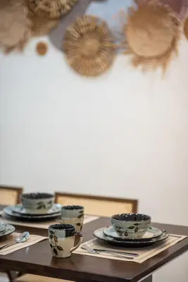 a table with plates and cups on top of it at De Luma TheRumah 5 bedroom 3 bathroom in Bukit Mertajam