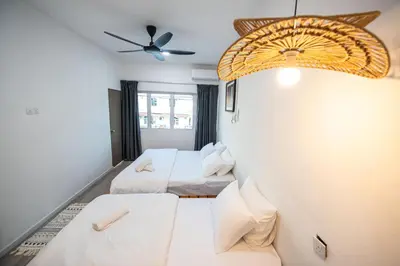 a room with two beds and a ceiling fan at De Luma TheRumah 5 bedroom 3 bathroom in Bukit Mertajam