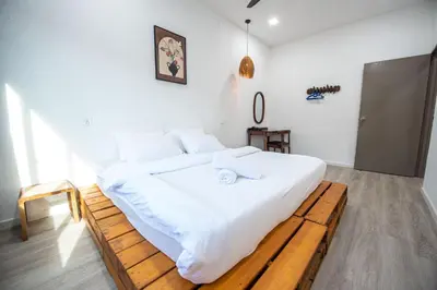 a bedroom with a large white bed on a wooden platform at De Luma TheRumah 5 bedroom 3 bathroom in Bukit Mertajam