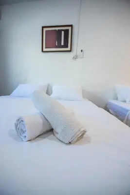 a white bed with towels on top of it at De Luma TheRumah 5 bedroom 3 bathroom in Bukit Mertajam