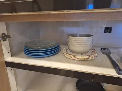 a shelf with plates and a bowl on it at Seaput Homes in Ayer Itam