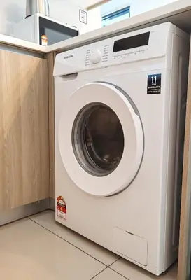 a white washing machine sitting in a kitchen at \u69df\u57ce\u4e2d\u8def\u4e09\u623f \u7231\u5c45\u5c4b in George Town