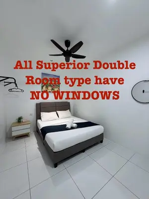 a bedroom with a bed with a ceiling fan at TDOZE Hotel in Brinchang