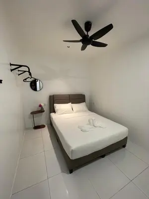 a bedroom with a bed with a ceiling fan at TDOZE Hotel in Brinchang