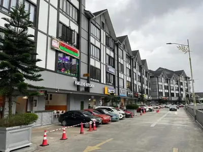a parking lot with cars parked in front of a building at TDOZE Hotel in Brinchang
