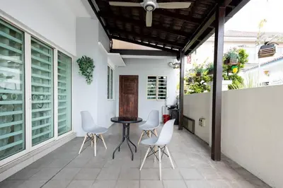 a patio with white chairs and a table on a building at Retro Homestay Ipoh - Semi D 15pax Wedding in Ipoh