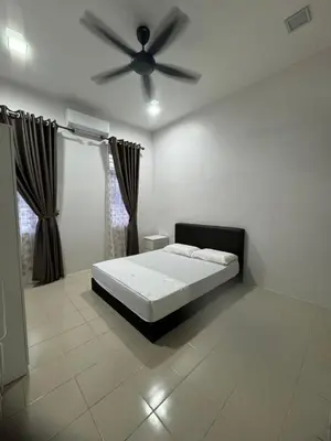 a bedroom with a bed and a ceiling fan at Homestay Kakak Adek 3 in Parit Buntar