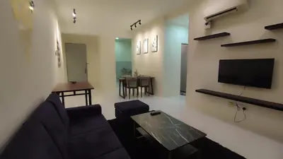 a living room with a couch and a flat screen tv at Sweet Home Ipoh Oasis Condominium in Ipoh
