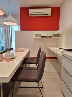 a kitchen with a table and chairs and a red wall at Modern & Relax Studio Penang in George Town