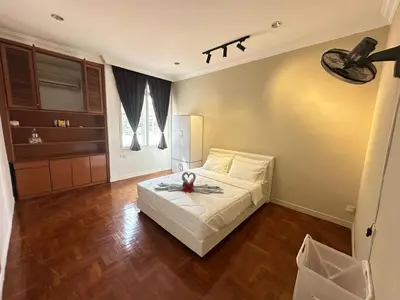 a bedroom with a white bed and a kitchen at Melon Resort in Jelutong