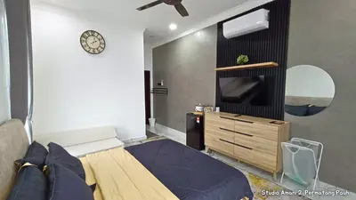 a bedroom with a bed and a dresser and a tv at Studio Amani 2 Permatang Pauh in Permatang Pauh