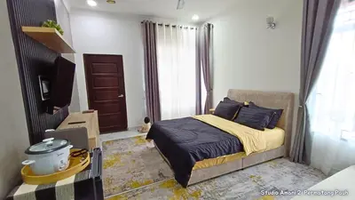 a bedroom with a bed and a television in it at Studio Amani 2 Permatang Pauh in Permatang Pauh