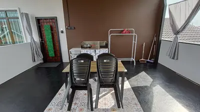 a dining room with a table and two black chairs at Studio Amani 2 Permatang Pauh in Permatang Pauh